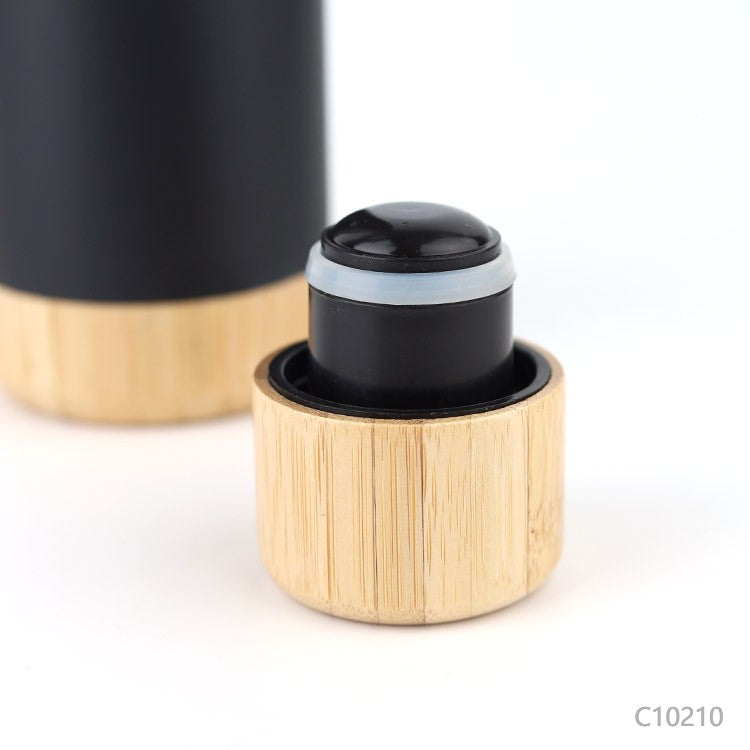 Detalle botella térmica con tapa y base de bambú para regalos empresariales, se puede agregar logo utilizando grabado láser fibra en la botella o grabado láser en la tapa