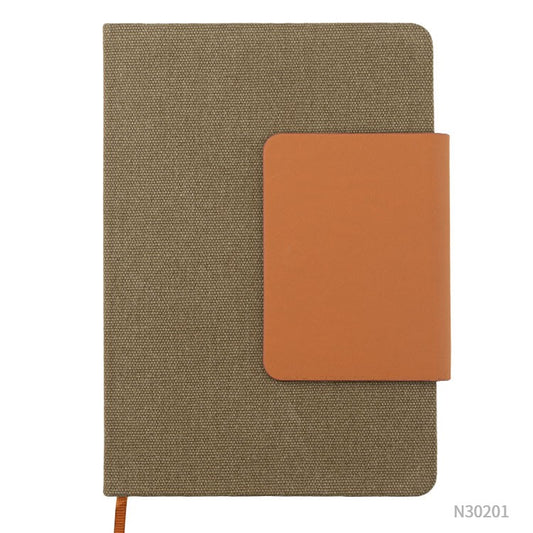 Cuaderno A5 en tela ecológica detalle en PU eco cuero. Puede personalizarse, para regalos promocionales, con un logotipo impreso en 1 tinta o con grabado láser.