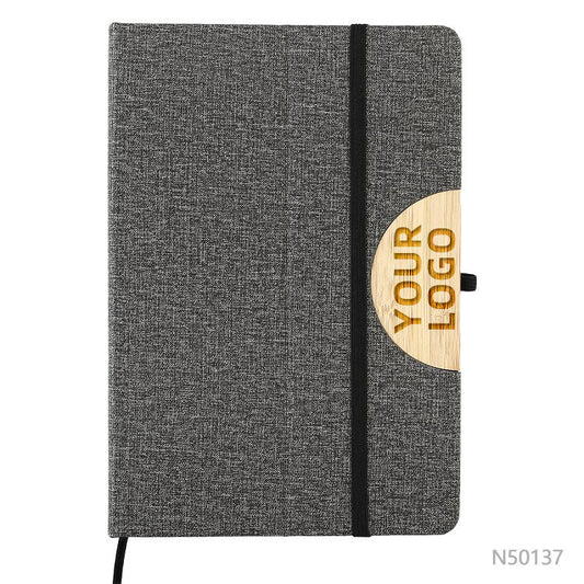 Cuaderno porta celular de tela R-PET y detalle en bambú, disponible en colores gris o negro. Logotipo en grabado láser en la tapa.