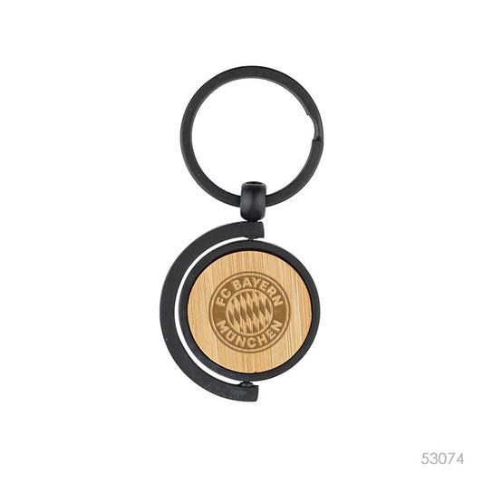 Llavero de bambú y metal con un logo.